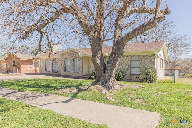 single story home with a front yard, fence, roof with shingles, and crawl space