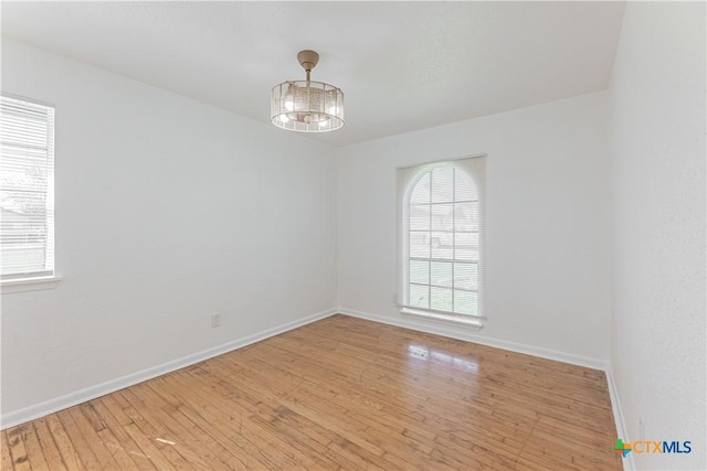 empty room featuring baseboards and light wood-style floors