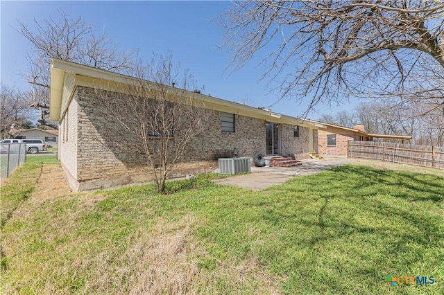 rear view of property with entry steps, a patio area, a lawn, and fence