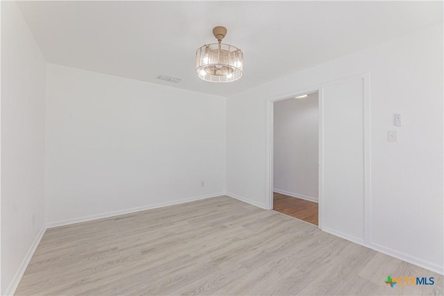 spare room with visible vents, baseboards, and light wood-style floors