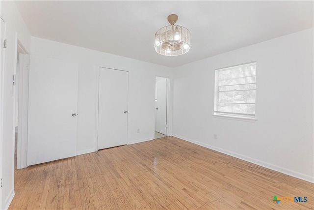 unfurnished bedroom featuring baseboards and light wood finished floors