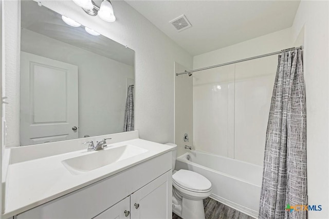 full bathroom with toilet, shower / bathtub combination with curtain, hardwood / wood-style flooring, and vanity