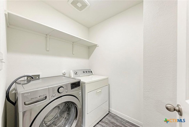 clothes washing area featuring dark hardwood / wood-style floors and independent washer and dryer