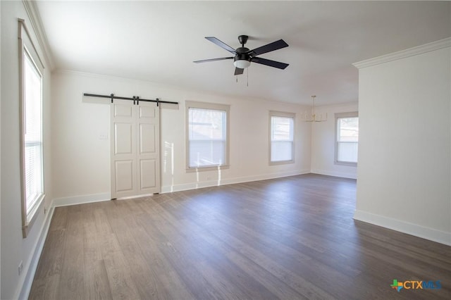 spare room featuring ceiling fan with notable chandelier, a barn door, dark hardwood / wood-style flooring, and ornamental molding