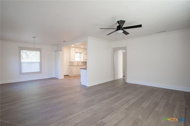 unfurnished living room with ceiling fan, wood-type flooring, and ornamental molding