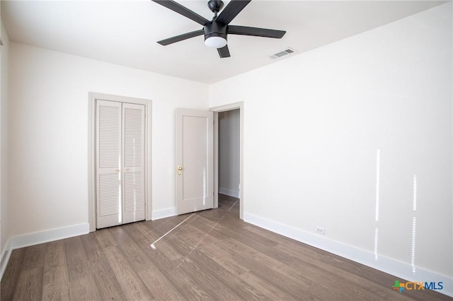 unfurnished bedroom featuring a closet, light hardwood / wood-style flooring, and ceiling fan