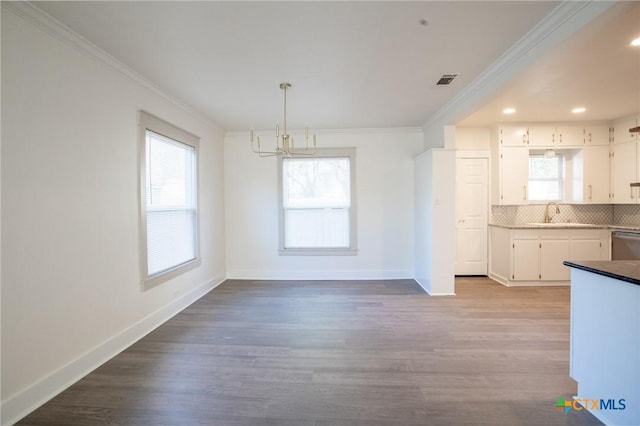 unfurnished dining area featuring crown molding, plenty of natural light, light hardwood / wood-style floors, and a notable chandelier