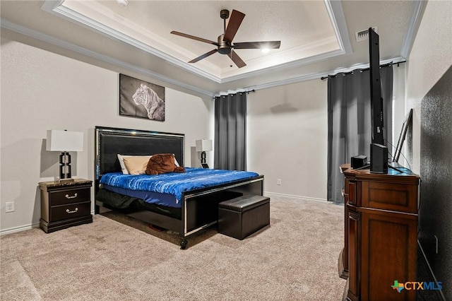 carpeted bedroom featuring ceiling fan, crown molding, and a tray ceiling