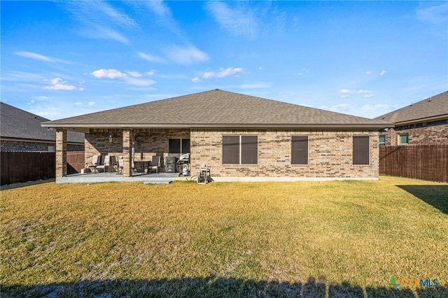 rear view of property with a yard and a patio