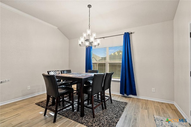 dining room featuring light hardwood / wood-style flooring, crown molding, and an inviting chandelier