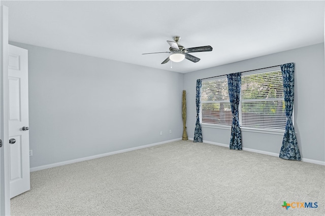 spare room with light colored carpet and ceiling fan