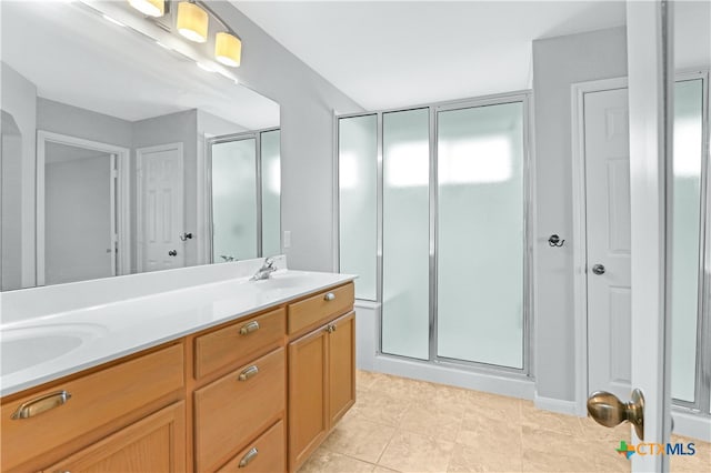 bathroom featuring tile patterned flooring, vanity, and a shower with shower door