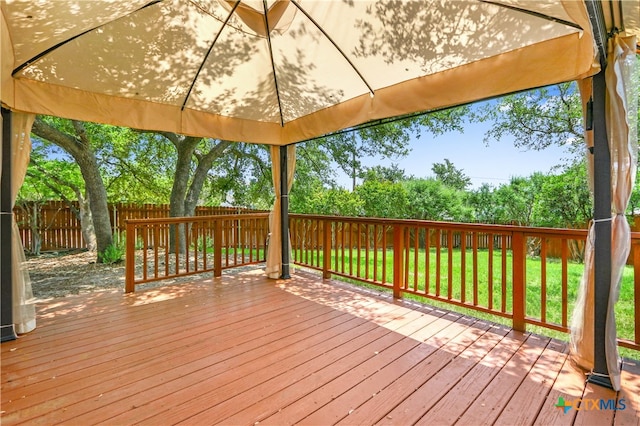 wooden terrace with a gazebo and a lawn