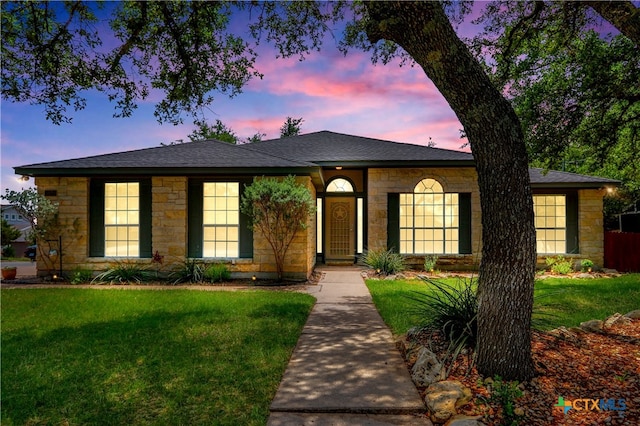 ranch-style home featuring a yard