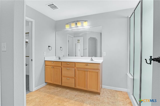 bathroom featuring vanity and a shower with shower door