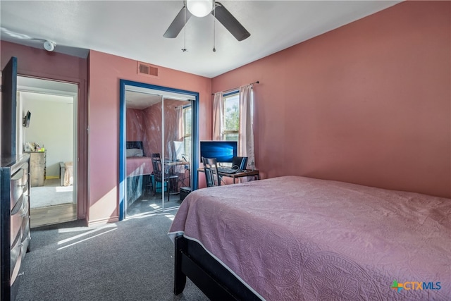 bedroom with ceiling fan, dark colored carpet, and a closet