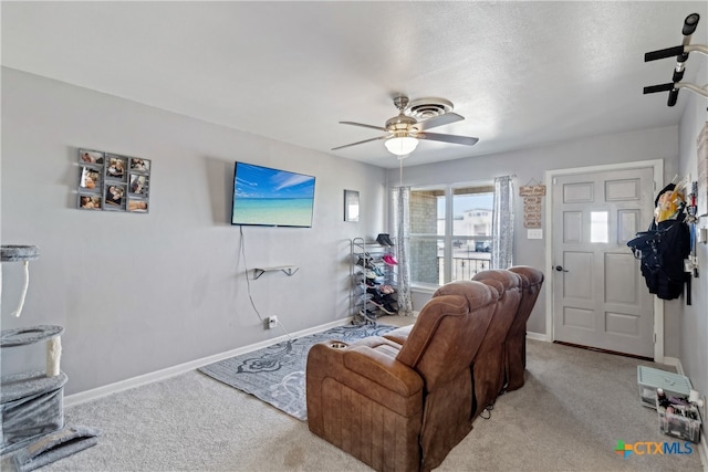 carpeted living room with a textured ceiling and ceiling fan