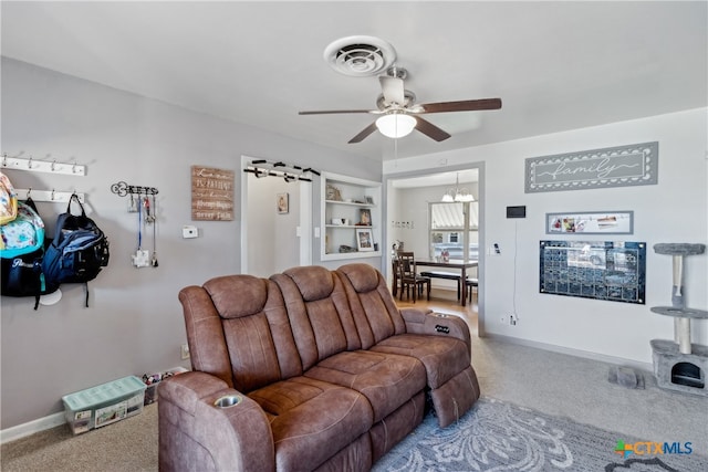 living room with ceiling fan with notable chandelier and carpet