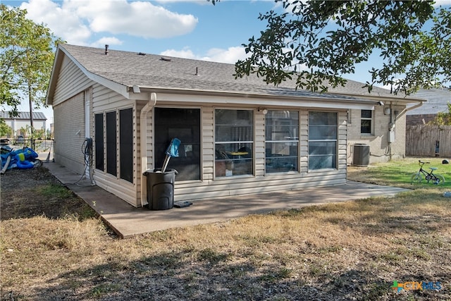 back of property with cooling unit and a lawn