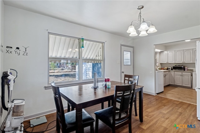 dining room with light hardwood / wood-style floors and a chandelier