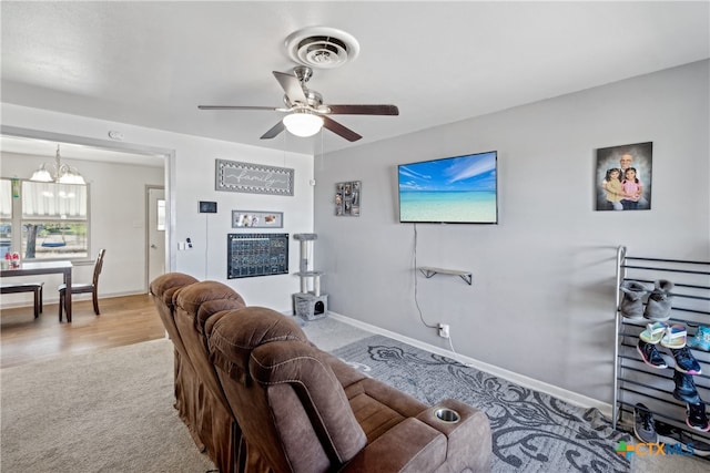 living room with ceiling fan with notable chandelier and light carpet