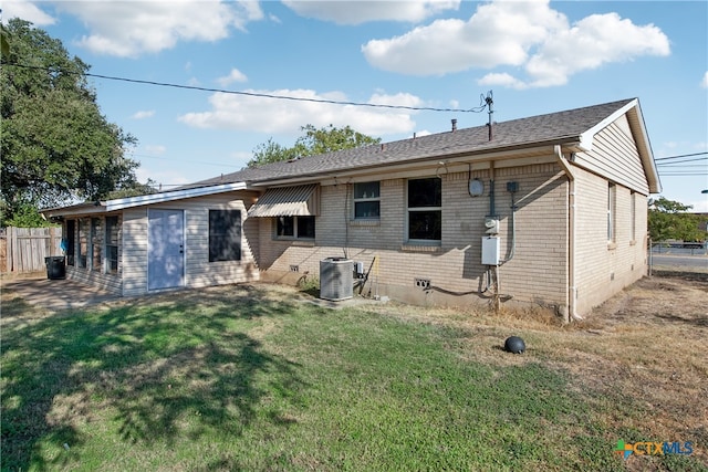 back of house featuring central AC and a yard