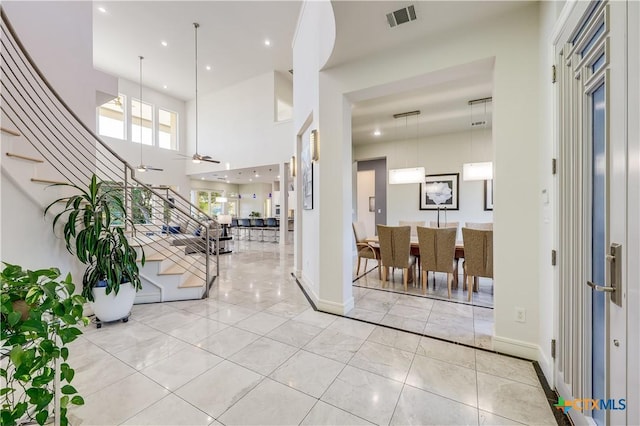 entrance foyer featuring ceiling fan and a high ceiling