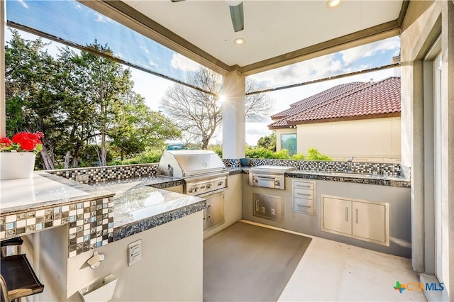 view of patio with area for grilling, sink, and exterior kitchen