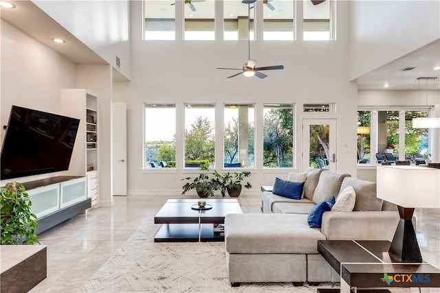 living room with a high ceiling and ceiling fan