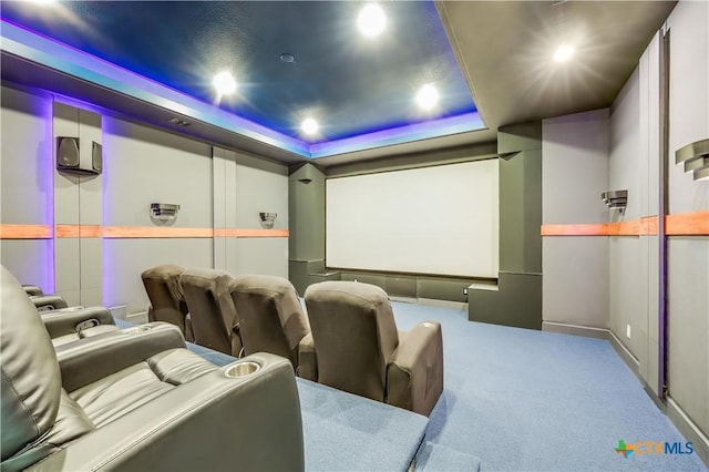 carpeted home theater room featuring a tray ceiling