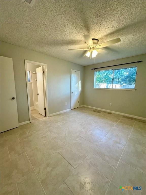 5407 Shirley St, Baytown, TX 77521 - unfurnished bedroom featuring light tile patterned floors, a textured ceiling, baseboards, a ceiling fan, and connected bathroom