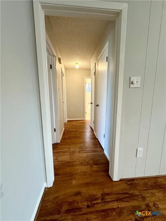 5407 Shirley St, Baytown, TX 77521 - corridor featuring dark wood finished floors, a textured ceiling, and baseboards