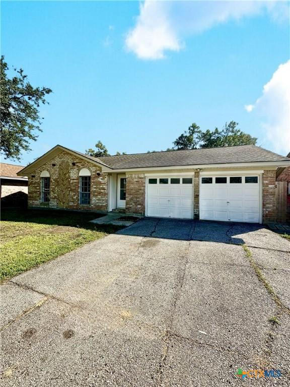 5407 Shirley St, Baytown, TX 77521 - single story home featuring driveway, an attached garage, brick siding, and a front yard