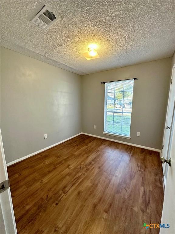 5407 Shirley St, Baytown, TX 77521 - unfurnished room featuring dark wood finished floors, a textured ceiling, and baseboards