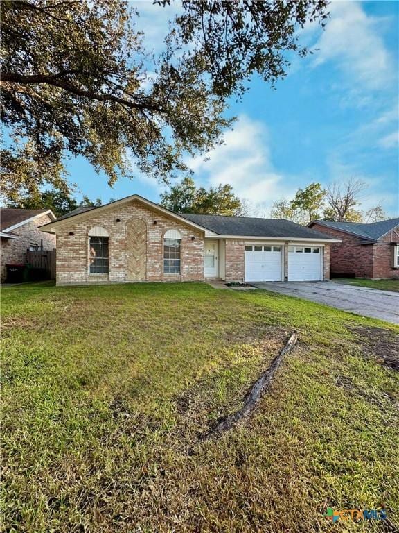 5407 Shirley St, Baytown, TX 77521 - view of front of house with driveway, a garage, a front lawn, and brick siding