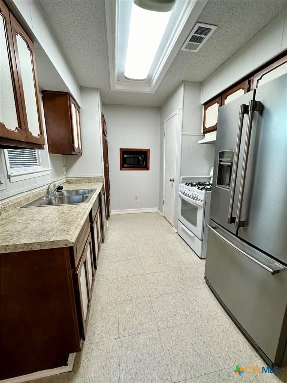 5407 Shirley St, Baytown, TX 77521 - kitchen with high end refrigerator, white range with gas stovetop, a sink, light floors, and light countertops