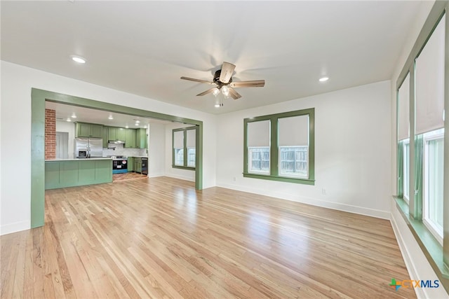 unfurnished living room featuring ceiling fan and light wood-type flooring