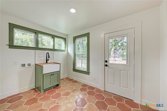 laundry area featuring cabinets, plenty of natural light, washer hookup, and sink