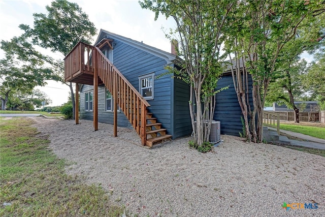 rear view of house featuring central air condition unit and a wooden deck