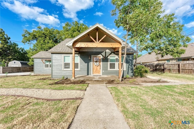 bungalow with a front lawn and covered porch