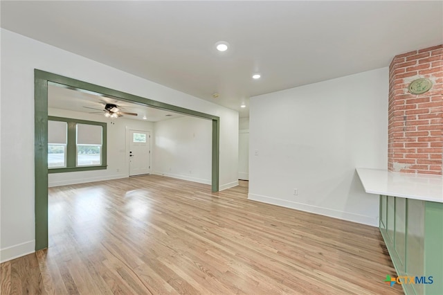 unfurnished living room with ceiling fan and light wood-type flooring