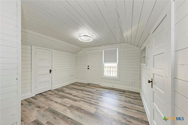 interior space with wooden walls, light wood-type flooring, lofted ceiling, and wood ceiling