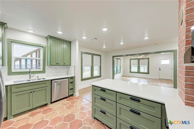 kitchen featuring tasteful backsplash, green cabinetry, sink, light hardwood / wood-style floors, and dishwasher