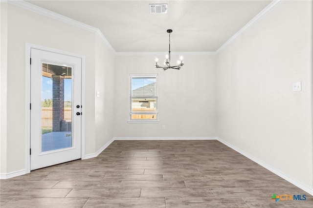 unfurnished dining area featuring a chandelier and crown molding