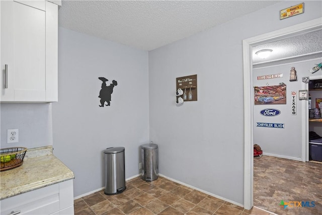 138 Antrim Dr, San Antonio, TX 78218 - kitchen with a textured ceiling, white cabinets, and light stone counters