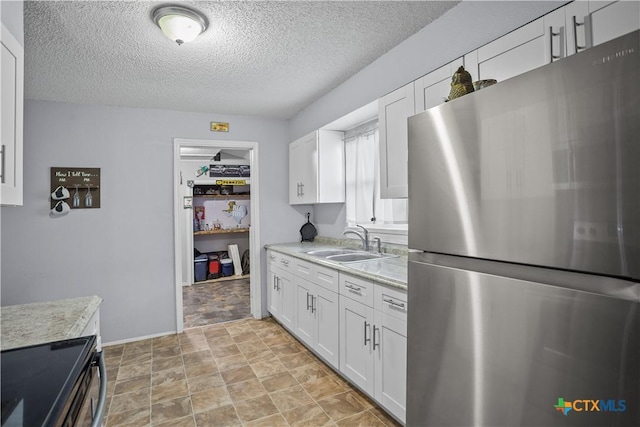 138 Antrim Dr, San Antonio, TX 78218 - kitchen with appliances with stainless steel finishes, a sink, light countertops, a textured ceiling, and white cabinetry