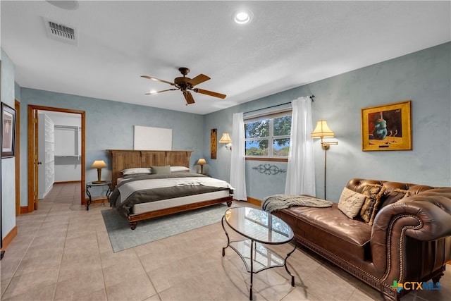 tiled bedroom with a textured ceiling and ceiling fan