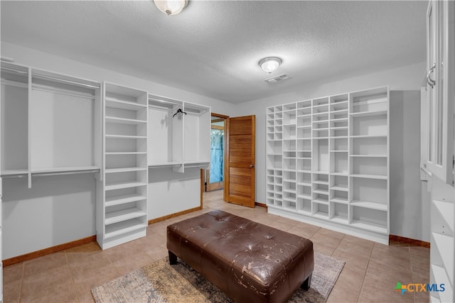 walk in closet with tile patterned floors