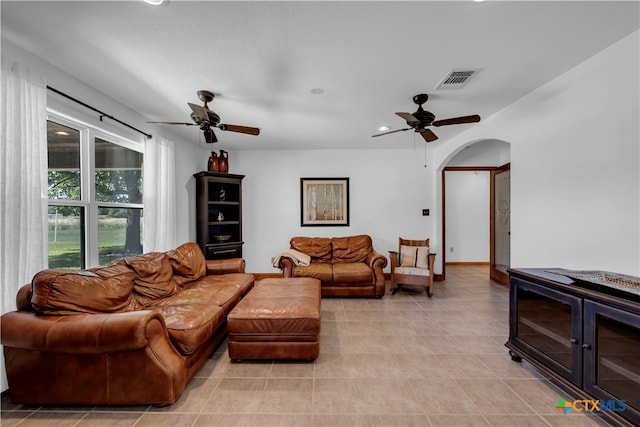 tiled living room featuring ceiling fan and a textured ceiling