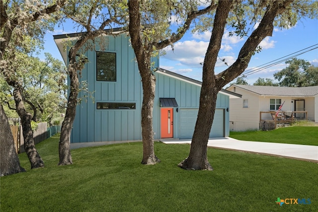 view of front of home with a front lawn, fence, board and batten siding, concrete driveway, and an attached garage